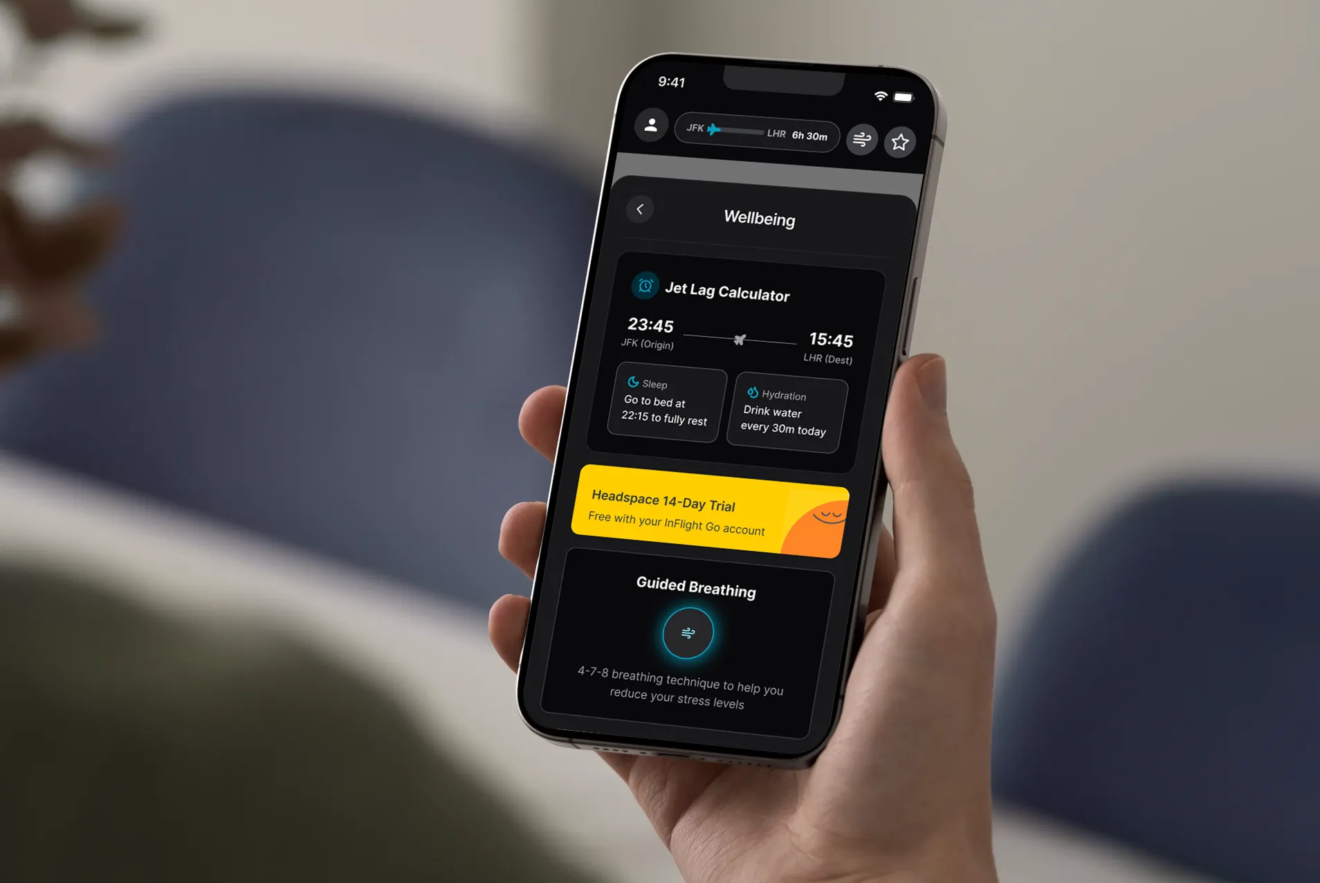 Passenger holding a phone showing the in-flight portal's wellbeing screen, with a jet-lag calculator and guided breathing.